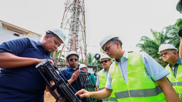 Menteri Komunikasi Datuk Fahmi Fadzil (kanan) menggunakan handy nemo untuk menguji kualiti liputan selular 4G dan 5G ketika melawat menara telekomunikasi Sapagaya sempena lawatan kerja beliau ke Tawau dan Lahad Datu hari ini. Turut hadir Ketua Setiausaha Kementerian Komunikasi Datuk Seri Mohamad Fauzi Md Isa (dua, kanan). - BERNAMA