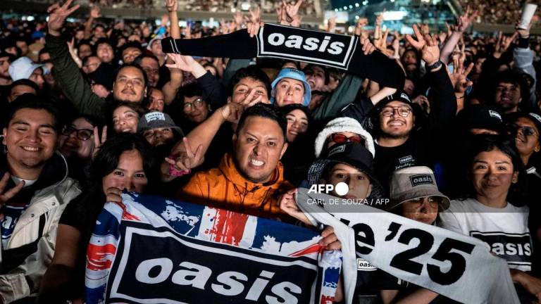 Fans gesture as they wait to see British band Oasis perform at the GNP Seguros Stadium in Mexico City on September 12, 2025. (Photo by Carl de Souza / AFP)