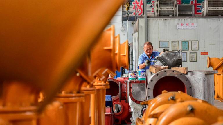 An employee works on a water pump production line at a factory in Qingzhou, in eastern China’s Shandong province on June 30, 2025. - AFPpix