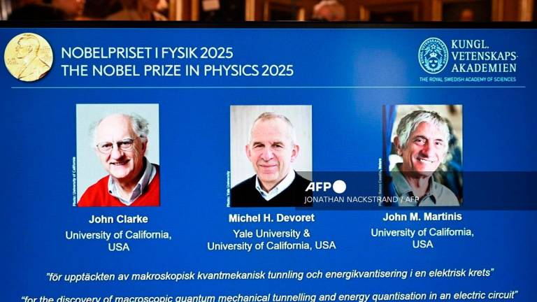 Photos of (LtoR) British physicist John Clarke at the University of California, USA, French physicist Michel H Devoret (University of California and Yale) and US physicist John M Martinis (University of California) are seen on a screen during a press conference on the awarding of the 2025 Nobel Prize in Physics at the Royal Swedish Academy of Sciences in Stockholm, Sweden, on October 7, 2025. - Jonathan Nackstrand / AFP