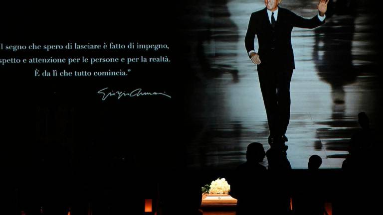 People queue to see the coffin of late Italian fashion designer Giorgio Armani lying-in state for two days at the Armani Theatre in Milan as a picture of him is seen on a screen, on September 6, 2025. The screen reads “The mark I hope to leave is one of commitment, respect, and genuine care for people and for reality. “That’s where everything truly begins.” Giorgio Armani died on September 4, 2025 at 91. (Photo by Stefano RELLANDINI / AFP)