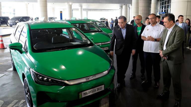 Menteri Pengangkutan Anthony Loke melihat kenderaan elektrik (EV) jenis BYD pada Majlis Perasmian Perkhidmatan Grab EV di Lapangan Terbang Antarabangsa Kuala Lumpur (KLIA) hari ini. - fotoBERNAMA