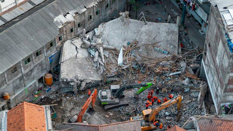 An aerial view shows rescuers searching for victims at the Al Khoziny Islamic boarding school in Sidoarjo, East Java, on October 5, 2025, after a multi-story building at the school collapsed during prayers, killing at least 37 people, with 26 others still missing, according to an official. (Photo by Dicky Bisinglasi / AFP)