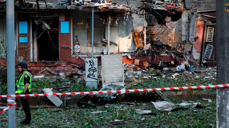 A member of the emergency services stands behind a cordon at a building, damaged during Russian drone and missile strikes, amid Russia’s attack on Ukraine, in Kyiv, Ukraine - Reuterspix