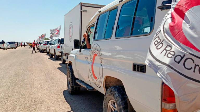 Syrian Red Crescent trucks carrying humanitarian aid arriving at Busra al-Sham in Syria’s southern Daraa province before crossing the buffer zone into Sweida province amidst a ceasefire following sectarian clashes between Druze fighters and Sunni Bedouin tribes earlier in the month. (Photo by SANA / AFP)