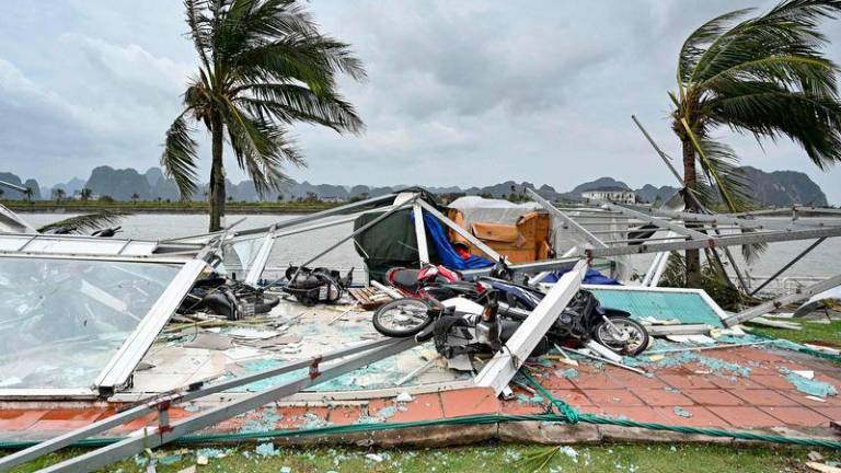 This picture shows swept motorbikes with the debris of destroyed waiting lounges on the shore after Super Typhoon Yagi hit Ha Long bay, in Quang Ninh province, on September 8, 2024. - AFPPIX