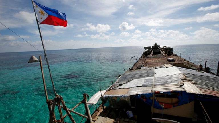 A Philippine flag flutters from a dilapidated Philippine Navy ship that has been aground since 1999 and became a Philippine military detachment on the disputed Second Thomas Shoal, part of the Spratly Islands, in the South China Sea - REUTERSpix