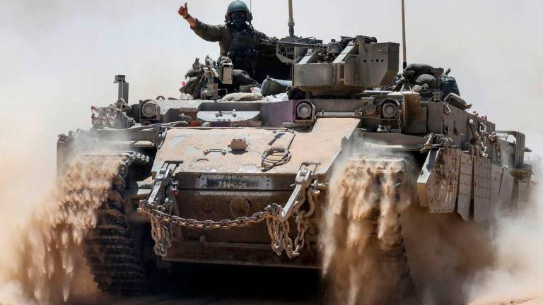 An Israeli soldier gestures atop a military vehicle at Israel’s southern border with the Gaza Strip on May 20, 2025. AFPpix