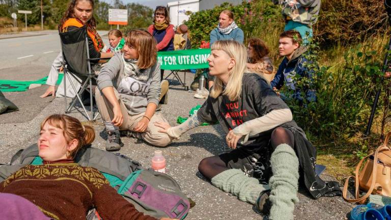 Swedish climate and political activist Greta Thunberg (L) and Norwegian artist and musician Aurora Aksnes (R) together with activists of climate protest group Extinction Rebellion at Equinor’s oil refinery in Mongstad, north of Bergen, Norway, on August 18, 2025. (Photo by Paul S. Amundsen / NTB / AFP)