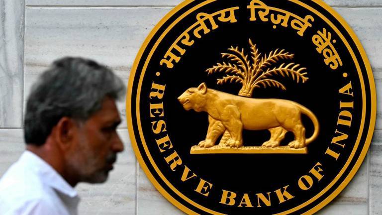 (FILES) A pedestrian walks past the Reserve Bank of India (RBI) logo outside its headquarters in Mumbai on February 7, 2025. - Indranil Mukherjee / AFP