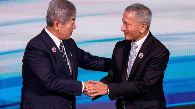 Japan’s Foreign Minister Takeshi Iwaya (L) is greeted by Singapore’s Minister for Foreign Affairs Vivian Balakrishnan (R) - Bernamapix