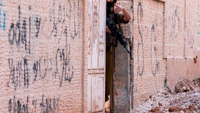 An Israeli soldier gestures as he enforces an evacuation order on a house in the Jenin refugee camp in the Israeli occupied West Bank on July 8, 2025. - Jaafar ASHTIYEH / AFP