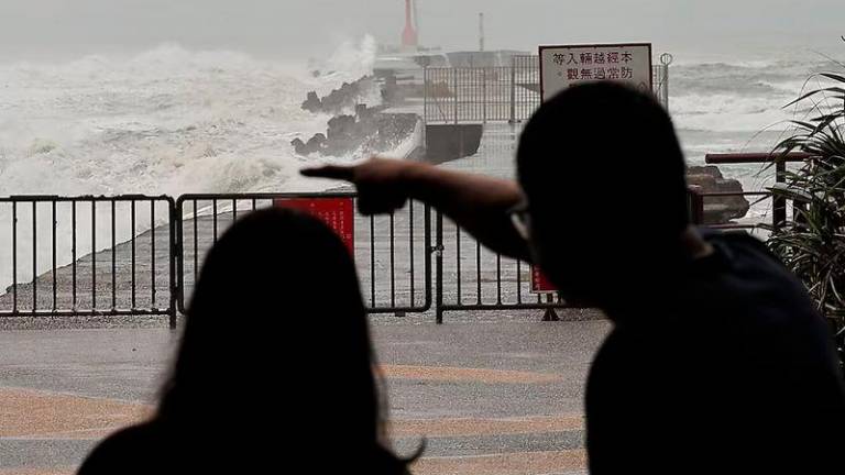 Tourists watch the waves as Typhoon Krathon approaches, in Kaohsiung - REUTERSpix