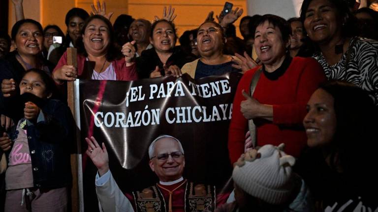 People pose next to the image of Robert Francis Prevost, who became Pope Leo XIV on May 8, 2025.AFPpix