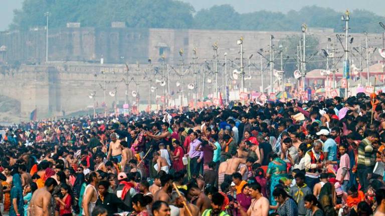 Hindu pilgrims take a holy dip at Sangam, the confluence of Ganges, Yamuna and mythical Saraswati rivers during the Maha Kumbh Mela festival in Prayagraj on February 5, 2025. (Photo by Idrees MOHAMMED / AFP)