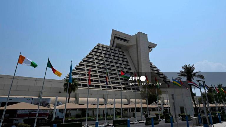 Flags fly in front of the hotel where the upcoming Arab-Islamic summit, organised to discuss the recent Israeli attack on Qatar will take place, in Doha on September 14, 2025. (Photo by MAHMUD HAMS / AFP)
