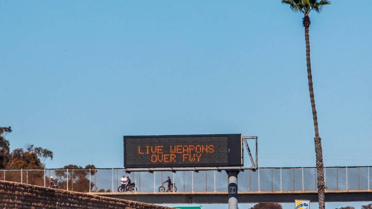 People watch the traffic as signs alert drivers about the closure of the 5 Freeway on October 18, 2025 in San Clemente, California. - Apu Gomes/Getty Images/AFP