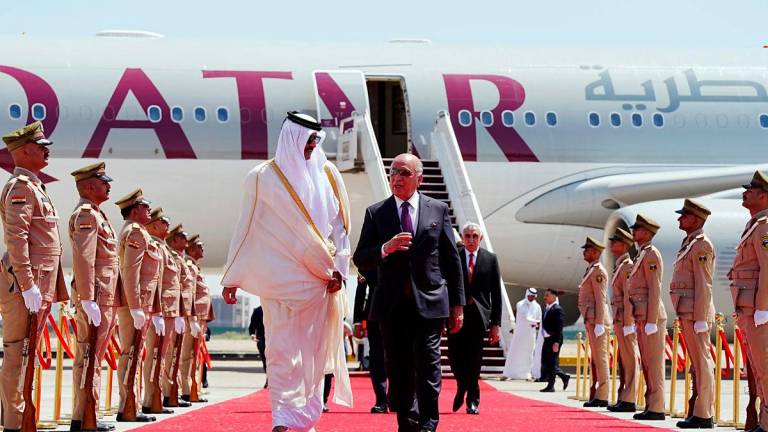 Iraq’s Foreign Minister Fuad Hussein (R) walks with Qatar’s Emir Sheikh Tamim bin Hamad al-Thani as he arrives in Baghdad ahead of the 34th Arab League summit on May 17, 2025. AFPpix