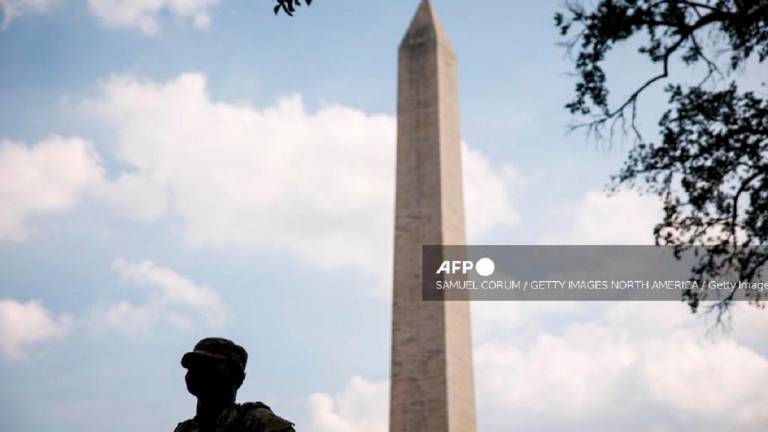 Members of the D.C. National Guard are positioned along Constitution Avenue near the White House and Washington Monument on August 17, 2025 in Washington, DC. - Samuel Corum/Getty Images/AFP