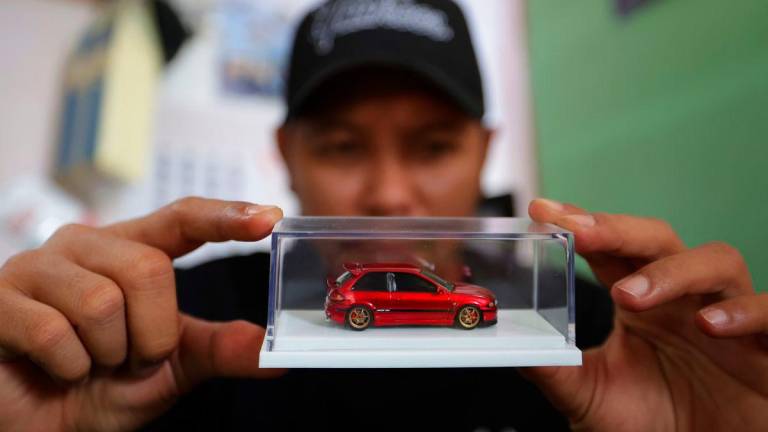 Juruteknik mesin cetak Mohd Jaidin Mustafa menunjukkan salah satu kereta miniatur berskala 1:64 yang telah siap diubah suai ketika ditemui Bernama di kediamannya di Kampung Changkat, Gombak baru-baru ini -BERNAMA