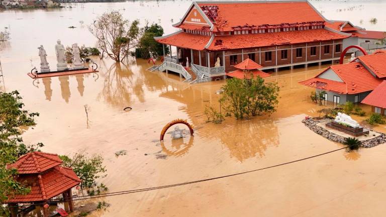 Flood waters surrounding a pagoda complex after typhoon Bualoi passed over Lam Thanh commune in Nghe An province on September 30, 2025. (Photo by Phan Duy / AFP)
