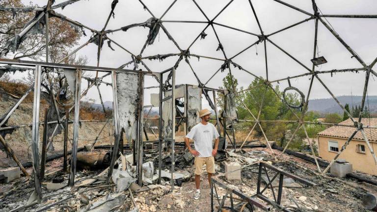 The owner of a tourist bubble home stands amid the damage caused following wildfires in Durban-Corbieres, in the Aude department, southern France on August 9, 2025- Photo by Idriss Bigou-Gilles / AFP