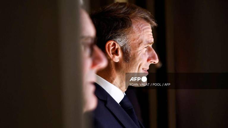 France's President Emmanuel Macron (R) and Britain's Prime Minister Keir Starmer (L) react as they wait for the arrival of Palestinian president Mahmud Abbas at the congress centre prior to attend the Sharm El-Sheikh Peace Summit, in the Egyptian Red Sea resort town of Sharm el-Sheikh, on October 13, 2025. - Pool via AFP