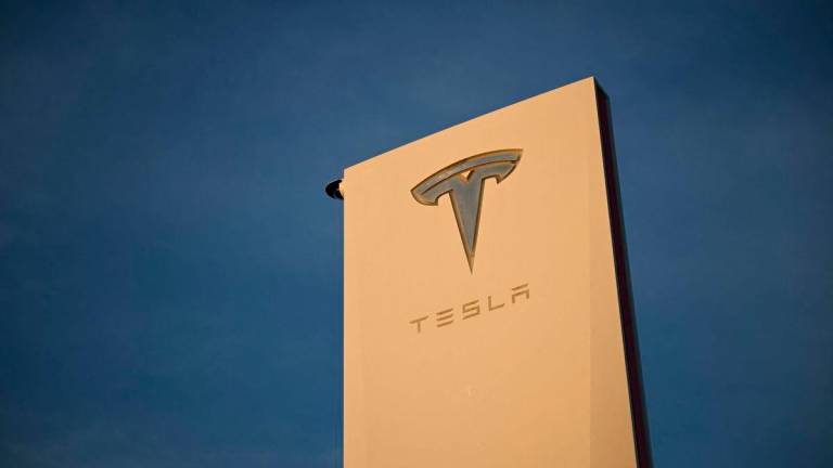 The Tesla, Inc. logo is displayed on a sign outside the Tesla Design Center in Hawthorne, California - AFPPix