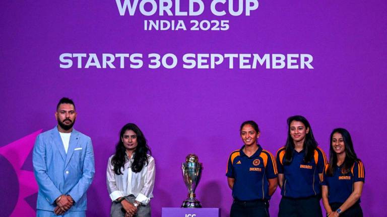 Indian team players Jemimah Rodrigues (R), Smriti Mandhana (2R) and Harmanpreet Kaur (C) pose with the trophy alongside former player Yuvraj Singh (L) during an event held to mark 50 days countdown to the 2025 ICC Women’s Cricket World Cup in Mumbai on August 11, 2025. Photo by Punit PARANJPE / AFP