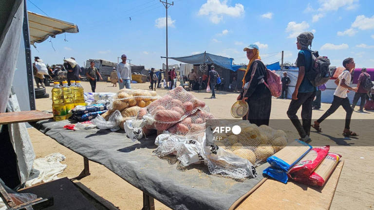 Palestinians look at foodstuffs for sale at a makeshift market in the Mawasi area of Rafah, amid a huge spike in prices of already scarce foodstuffs in the Israel-besieged Gaza Strip on July 20, 2025. - AFP