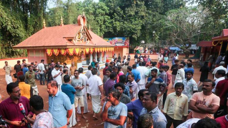 People gather after firecrackers explosion at the Anjootambalam Veererkavu temple in Kasaragod district of Kerala on October 29, 2024. - AFPPIX