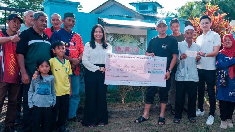 Timbalan Menteri Komunikasi Teo Nie Ching menyampaikan replika cek bernilai RM15,000 kepada Pengerusi Surau Nurul Haq Kampung Sungai Sayong 1 Mohd Anuar Repan (lima, kanan), hari ini, susulan insiden van jenazah milik surau itu yang dicuri dan remuk teruk akibat kemalangan Khamis lepas-fotoBERNAMA