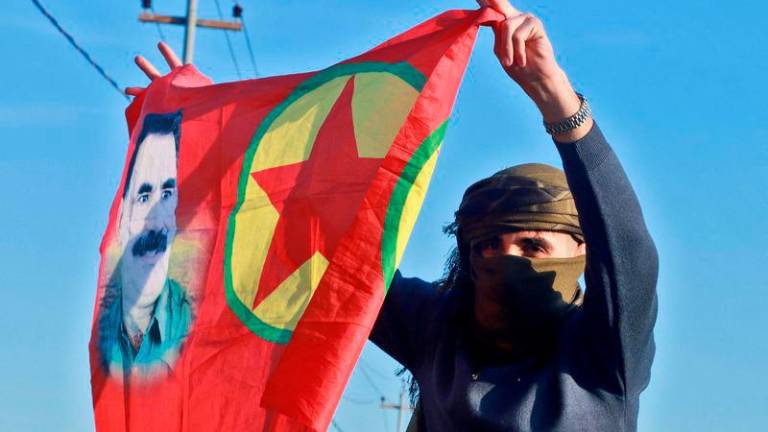 An Iraqi Kurdish woman waves a flag bearing the portrait of the founder of the Kurdistan Worker’s Party (PKK) Abdullah Ocalan as people gather at Freedom Park to listen to an audio message by the jailed leader in Sulaimaniyah, in Iraq’s autonomous Kurdistan reigion - AFPpix