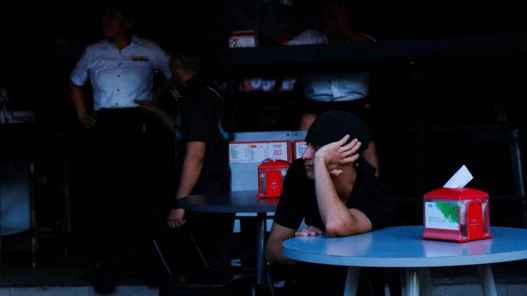 A tourist sits at a bar during a power grid collapse that caused a blackout across three states in southeastern Mexico, in Cancun, Mexico, September 26, 2025. - REUTERSPIX
