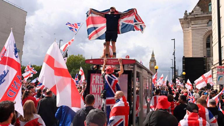 A protester stands on the bus stop during an anti-immigration rally organised by British anti-immigration activist Stephen Yaxley-Lennon, also known as Tommy Robinson, in London, Britain, September 13, 2025. REUTERS/Jaimi Joy