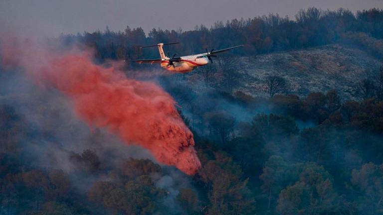 A DASH firefighting aircaft drops fire retardant during a wildfire near Bizanet, southwest France, on June 29, 2025. (Photo by IDRISS BIGOU-GILLES / AFP)