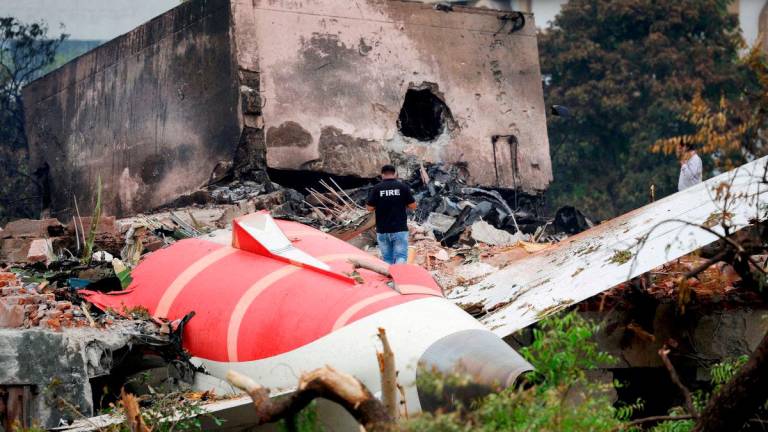 FILE PHOTO: A firefighter stands next to the crashed Air India Boeing 787-8 Dreamliner aircraft, in Ahmedabad, India, June 13, 2025. REUTERS/Adnan Abidi/File Photo