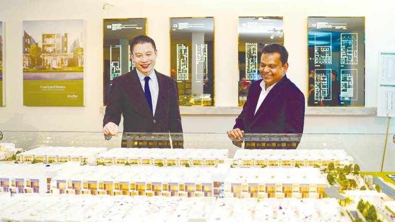 Berjaya Land executive director Tan Tee Ming (left) and Syed Ali looking at a scale model of Jesselton Courtyard at the prelaunch.