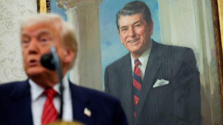A portrait of former U.S. President Ronald Reagan is seen in the background as U.S. President Donald Trump speaks during a swearing-in ceremony for the new U.S. ambassador to China, former U.S. Senator David Perdue, at the White House in Washington, D.C., U.S., May 7, 2025. REUTERSpix