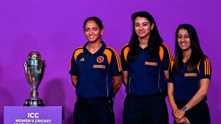 Indian team players Jemimah Rodrigues (R), Smriti Mandhana (C) and Harmanpreet Kaur pose with the trophy during an event held to mark 50 days countdown to the 2025 ICC Women’s Cricket World Cup in Mumbai on August 11, 2025. (Photo by Punit PARANJPE / AFP)
