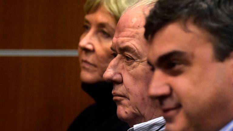 Defendants Ana Iewdiukow (L) and Pablo Carrasco (C), and a member of the legal team, Joaquin Toyos, attend the court hearing for the bankruptcy of the company Conexion Ganadera - AFPPix