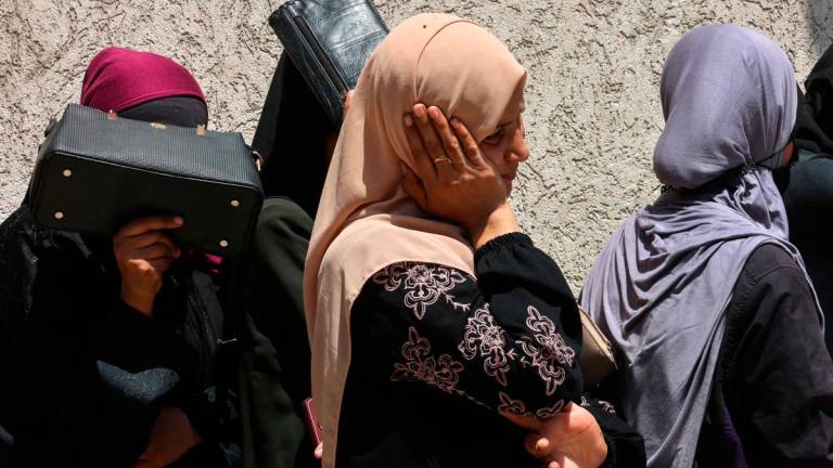 Palestinian women line up to receive bags of flour at a UN World Food Programme (WFP) warehouse on Al-Jalaa street in Gaza City, in the northern Gaza Strip on July 12, 2025. (Photo by Omar AL-QATTAA / AFP)