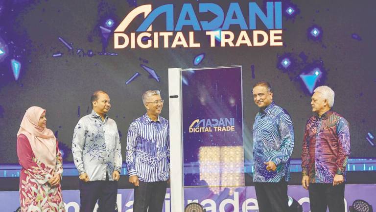 Tengku Datuk Seri Zafrul Abdul Aziz (centre) officiating at the launch of Madani Digital Trade today. With him are Matrade chairman Datuk Seri Reezal Merican Naina Merican (second, right), CEO Datuk Mohd Mustafa Abdul Aziz (right) and Nazsoft Tech CEO Dr Muhammad Nazrol Zawawi (second, left). – Bernamapic