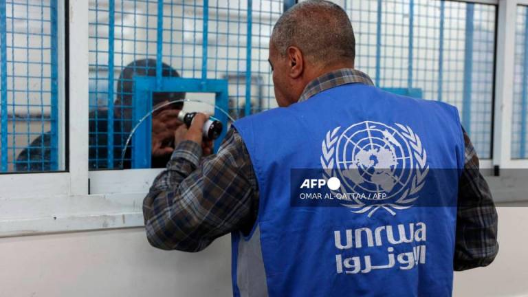 A member of staff dispenses a dose of medication to Palestinians at the UNRWA-run clinic at al-Shati refugee camp west of Gaza City on April 28, 2025. - AFPPIX