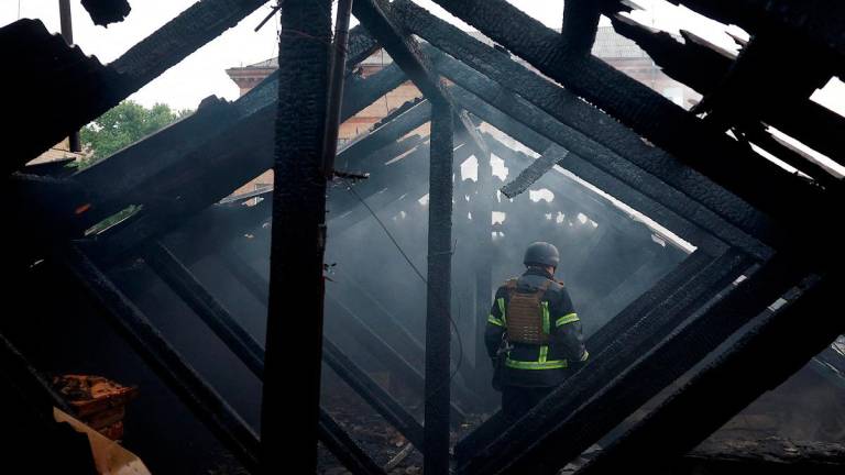 A firefighter stands on a roof of an apartment building, damaged during Russian drone and missile strikes, amid Russia’s attack on Ukraine, in Kyiv, Ukraine July 10, 2025. - REUTERS/Valentyn Ogirenko