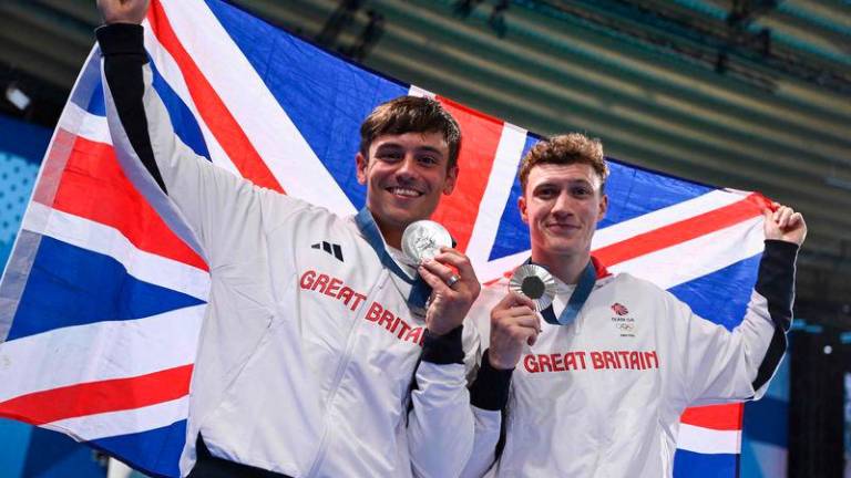 Silver medallists Britain’s Noah Williams (R) and Tom Daley celebrate with their medals following the men’s synchronised 10m platform diving at the Paris 2024 Olympic Games at the Aquatics Centre in Saint-Denis/AFPPIX