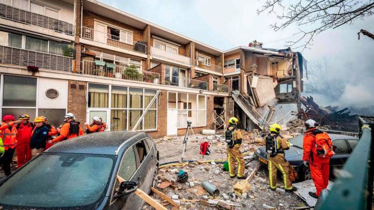 Firemen stand next to a partially collapsed residential building following a fire and an explosion in The Hague on December 7, 2024. - AFPPIX