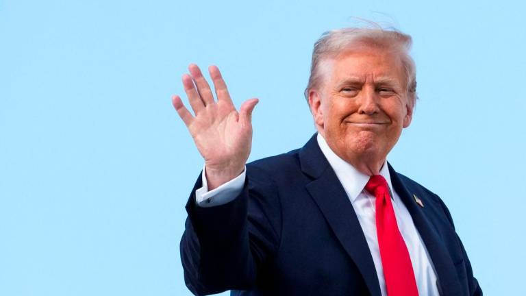 U.S. President Donald Trump gestures, while he boards Air Force One, as he departs for New York at Joint Base Andrews, Maryland, U.S., September 11, 2025. REUTERS/Ken Cedeno