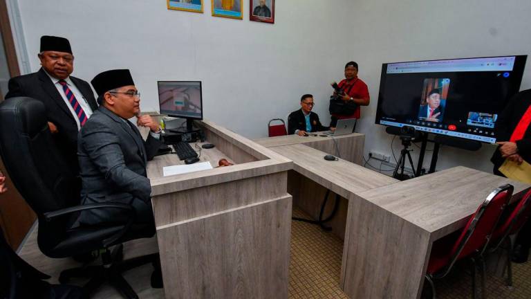 Ketua Hakim Syarie Kelantan, Datuk Ibrahim Deris (kiri), memberi penerangan kepada Exco Pembangunan Islam, Dakwah, Penerangan dan Hubungan Seranta, Mohd Asri Mat Daud (dua, kiri), pada Majlis Perasmian Dewan Mahkamah Teknologi di Mahkamah Syariah Kelantan, hari ini - BERNAMA