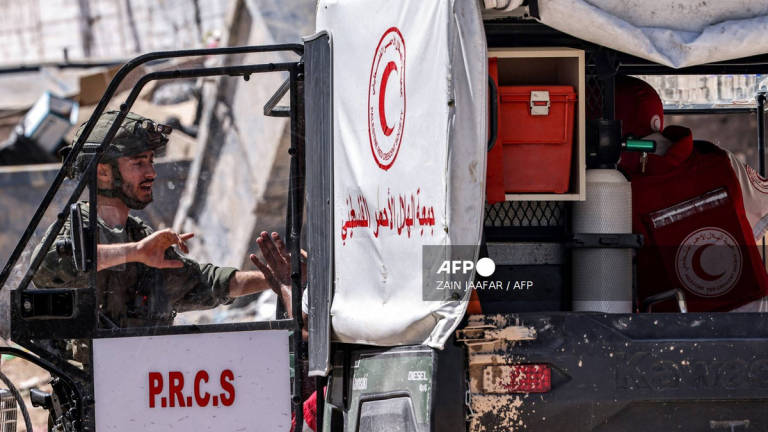 Israeli army soldiers positioned at the entrance of the Tulkarm camp for Palestinian refugees inspect a vehicle used by the Palestinian Red Crescent Society arriving at the scene, during an ongoing raid on the camp in the north of the occupied West Bank on September 12, 2024. - AFP